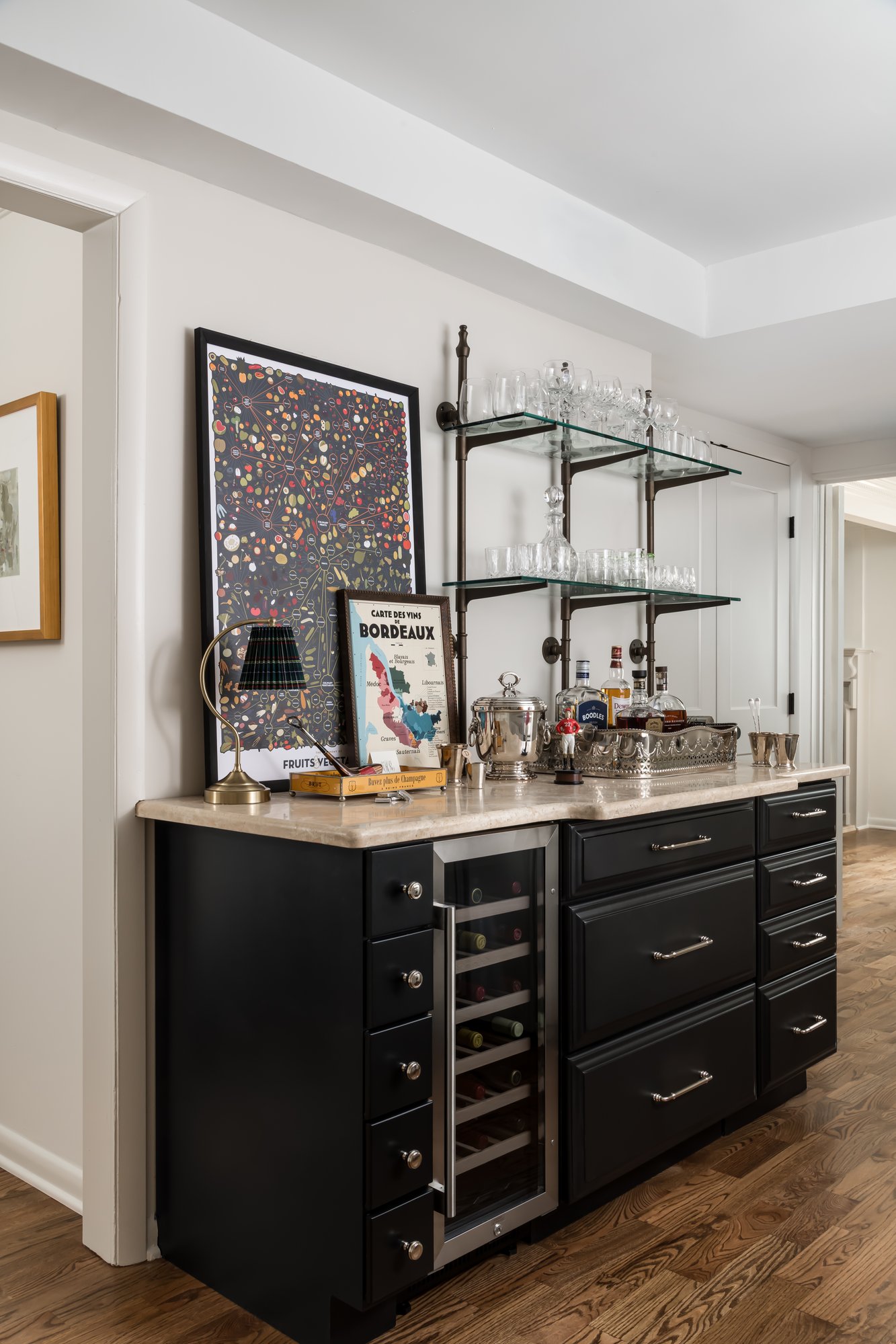 Image of a wine cabinet with black cabinets, brass knobs, and a mini fridge.