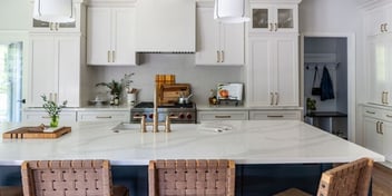 A remodeled luxury kitchen in Atlanta with an island-centric layout, white cabinets, and marble countertops. 