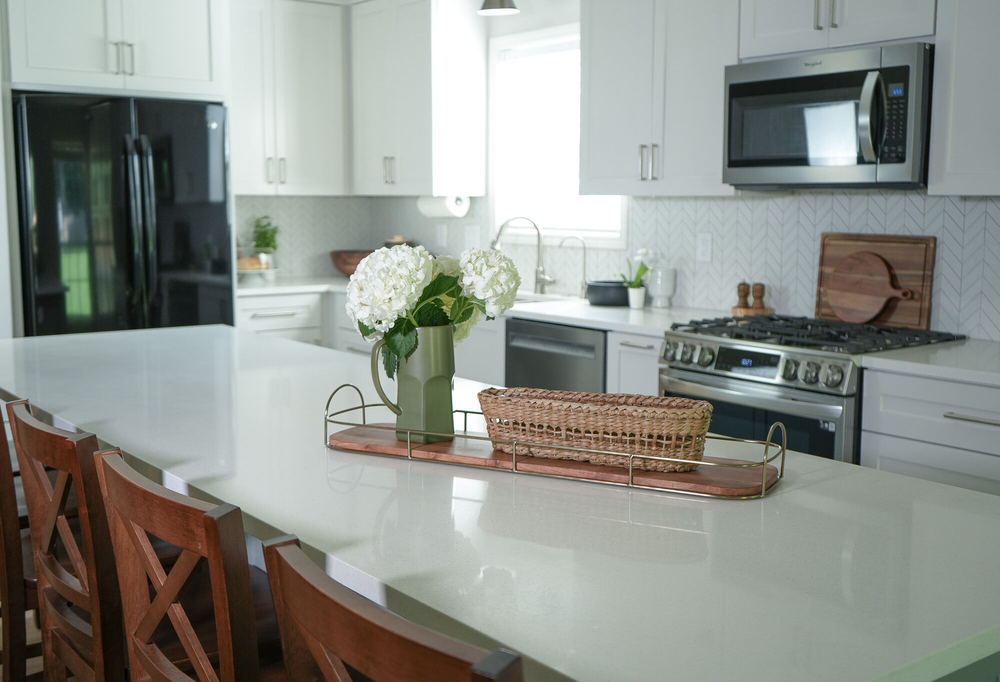 Elegant kitchen with floral centerpiece on large island in a Doraville, GA custom home by Exodus Design Build.