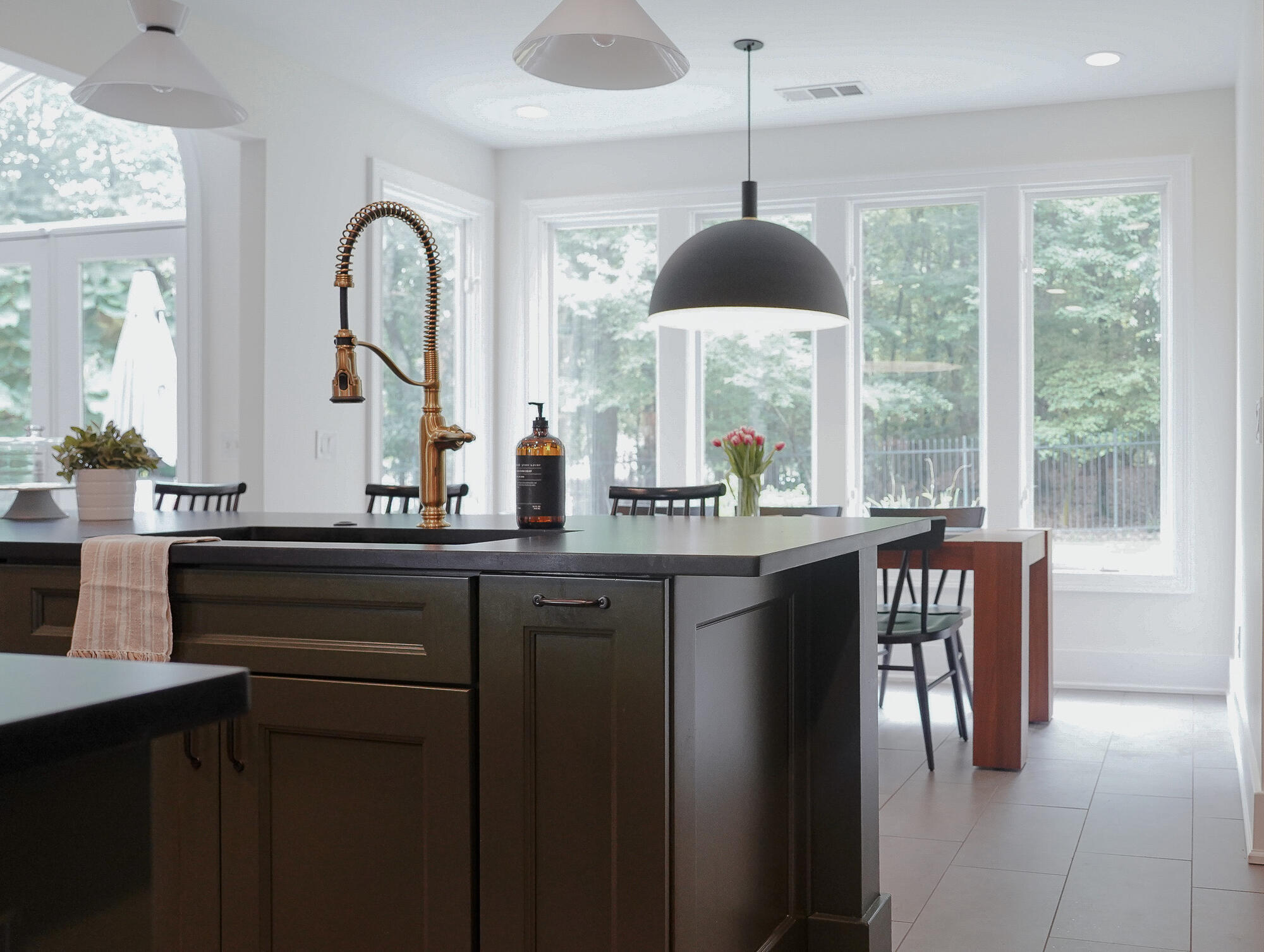 Kitchen sink island with brass faucet and view into dining area in a Fayetteville, GA custom home by Exodus Design Build Kitchen sink island with brass faucet and view into dining area in a Fayetteville, GA custom home by Exodus Design Build