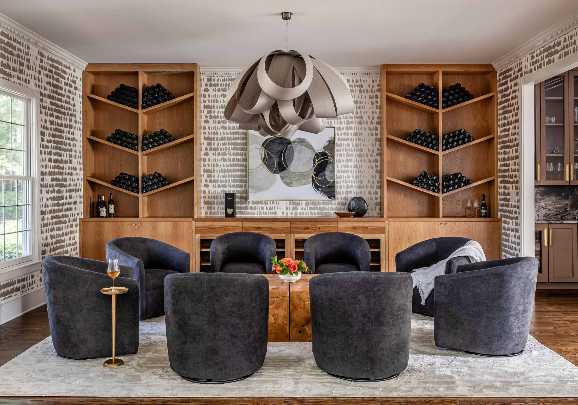 Modern wine room with geometric shelves and circular chandelier by Exodus Design Build in Redan, GA.