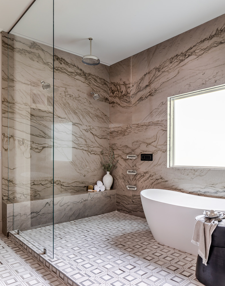 Designer walk-in shower with bookmatched marble and soaking tub by Exodus Design Build in Loganville, GA.