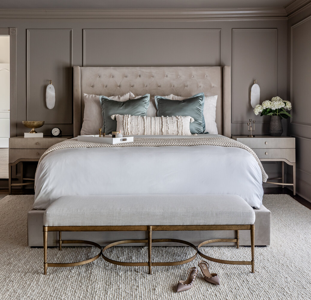 Sophisticated master bedroom with tufted headboard and gold-accented bench in Grayson, GA.