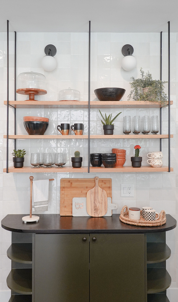 Floating wood kitchen shelves with glassware and plants in a custom home by Exodus Design Build in Decatur, GA.