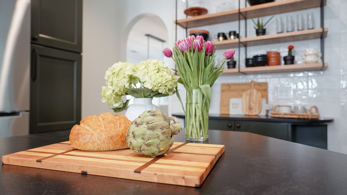 Kitchen island centerpiece with bread, tulips, and artichoke in a Grayson, GA custom home by Exodus Design Build.