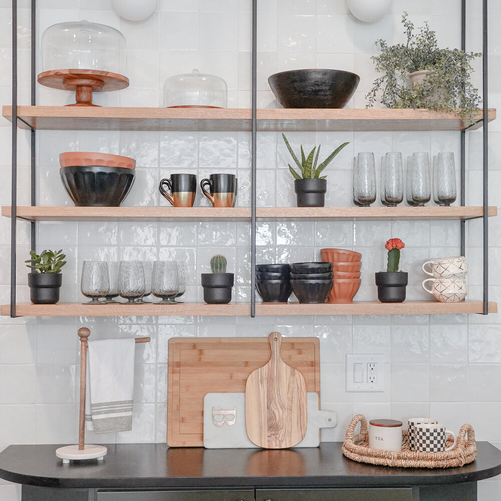 Modern kitchen shelves with black dishware and greenery in a Duluth, GA custom home by Exodus Design Build.