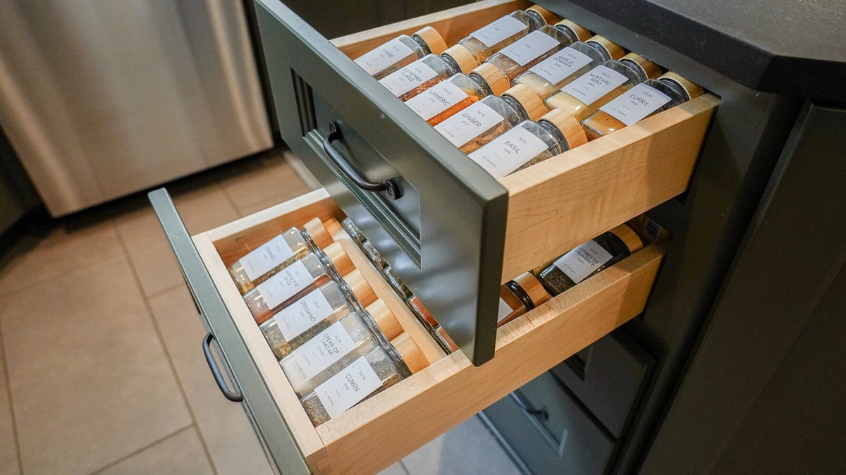 Organized spice drawer with labeled glass jars in a Braselton, GA custom home by Exodus Design Build.