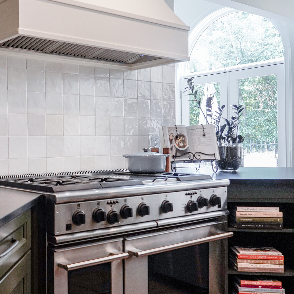 Stainless steel gas range and white tile backsplash in a Dacula, GA kitchen remodel by Exodus Design Build.