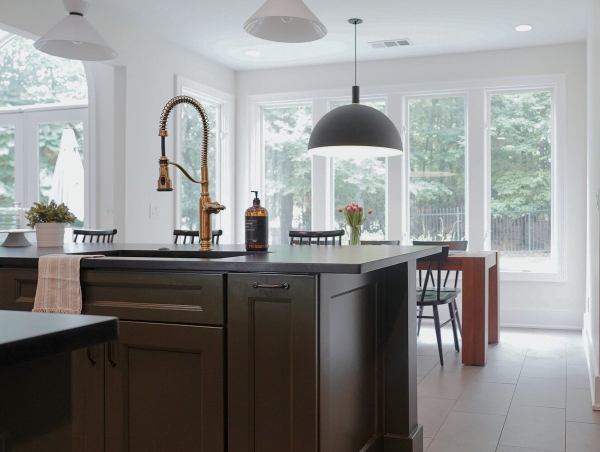 Stylish kitchen island with brass faucet and dining space by Exodus Design Build in Stone Mountain, GA.