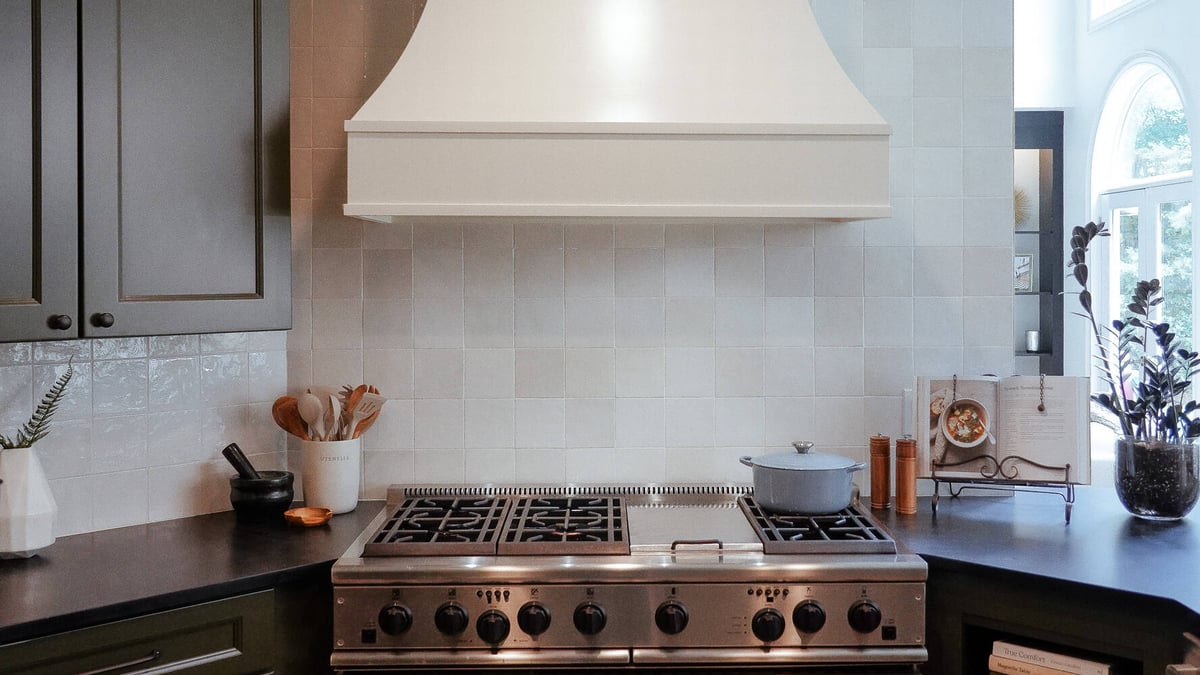White tile backsplash and professional gas range in a Suwanee, GA custom kitchen by Exodus Design Build.