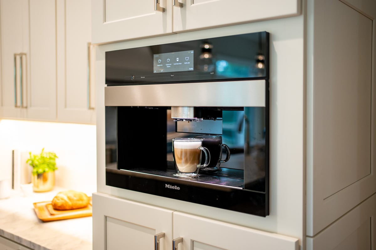 Built-in coffee bar with fresh cappuccino and undercabinet lighting by Exodus Design Build in Auburn, GA.