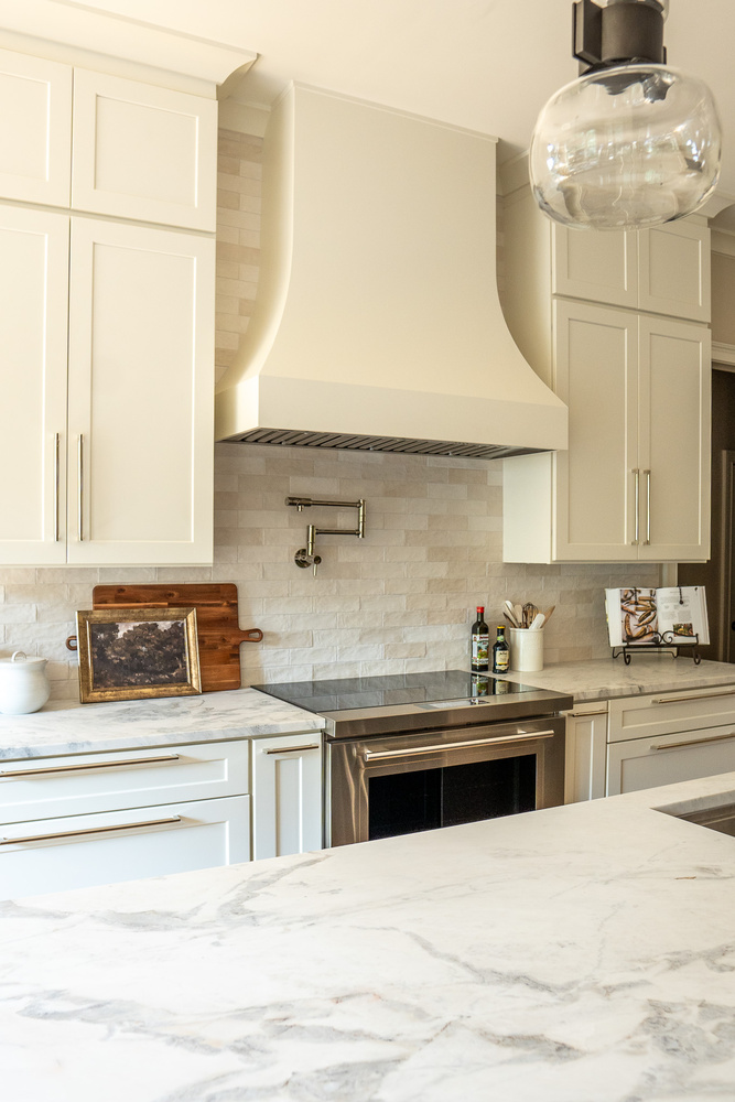 Close-up of range and custom range hood in luxury kitchen by Exodus Design Build in North Metro, GA