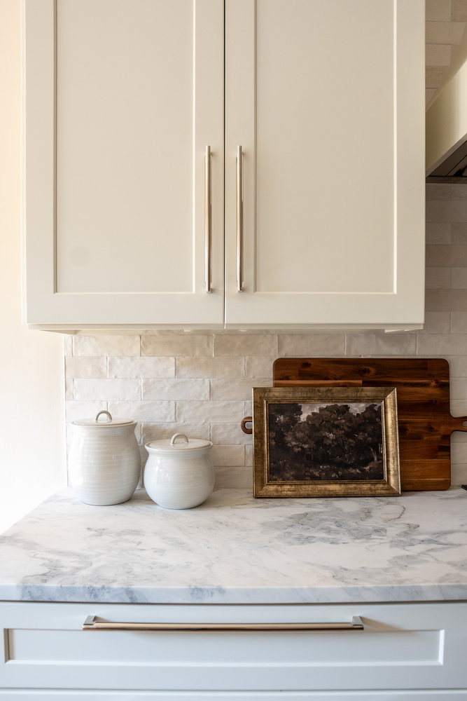 Kitchen corner styling with framed landscape and marble counters by Exodus Design Build in Snellville, GA
