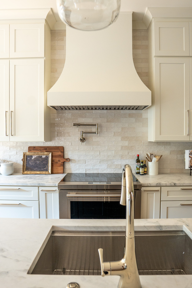 Symmetrical view of range hood and pot filler in custom kitchen by Exodus Design Build in Gainesville, GA