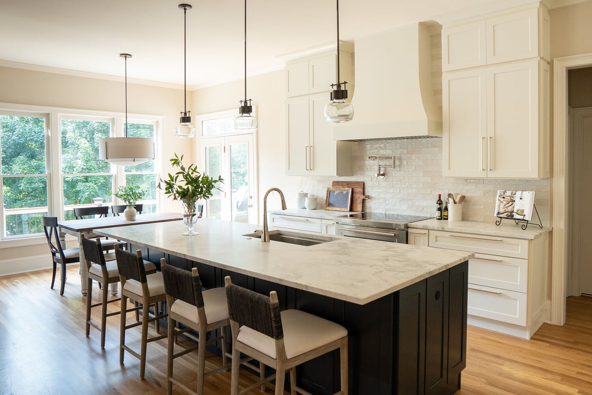 Wide kitchen angle showing island, pot filler, and marble countertops by Exodus Design Build in Tucker, GA.
