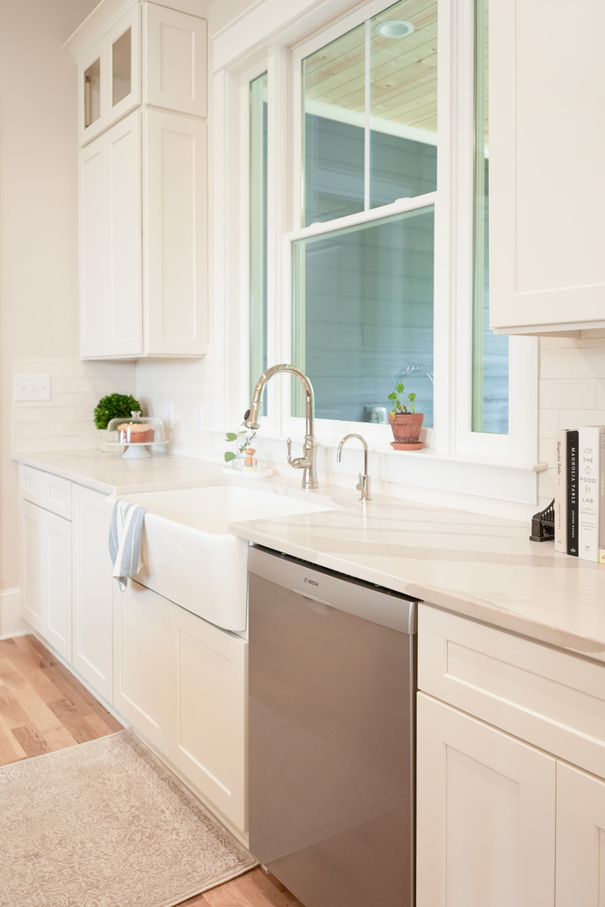Bright kitchen featuring apron sink and stainless appliances by Exodus Design Build in Decatur, GA