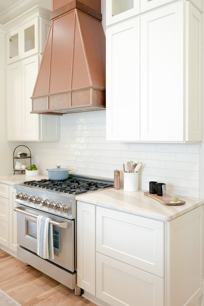 Copper kitchen range hood and stainless ZLINE oven in custom kitchen by Exodus Design Build in Gainesville, GA