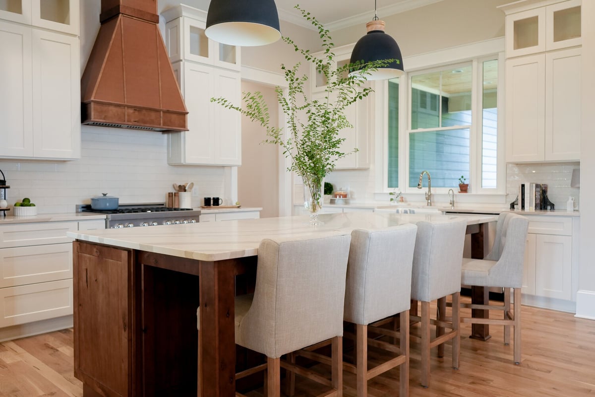 Elegant open-concept kitchen with wood island and black pendant lights by Exodus Design Build in Braselton, GA