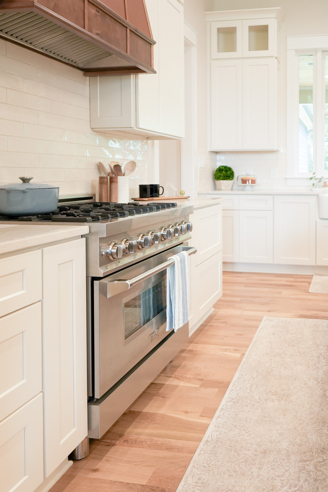 Luxury gas range with quartz countertops and custom cabinetry by Exodus Design Build in Dacula, GA