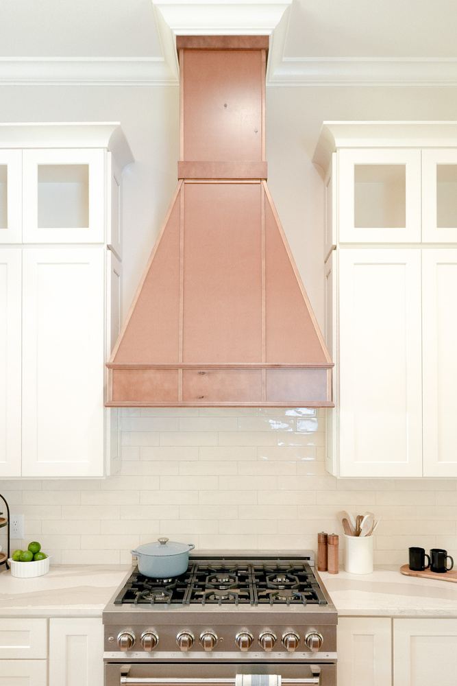 Luxury range wall with wood and white cabinetry contrast by Exodus Design Build in Hoschton, GA