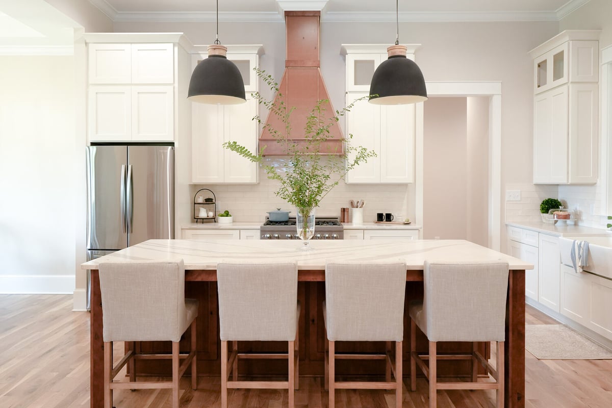 White cabinetry kitchen with natural wood accents and pendant lighting by Exodus Design Build in Grayson, GA
