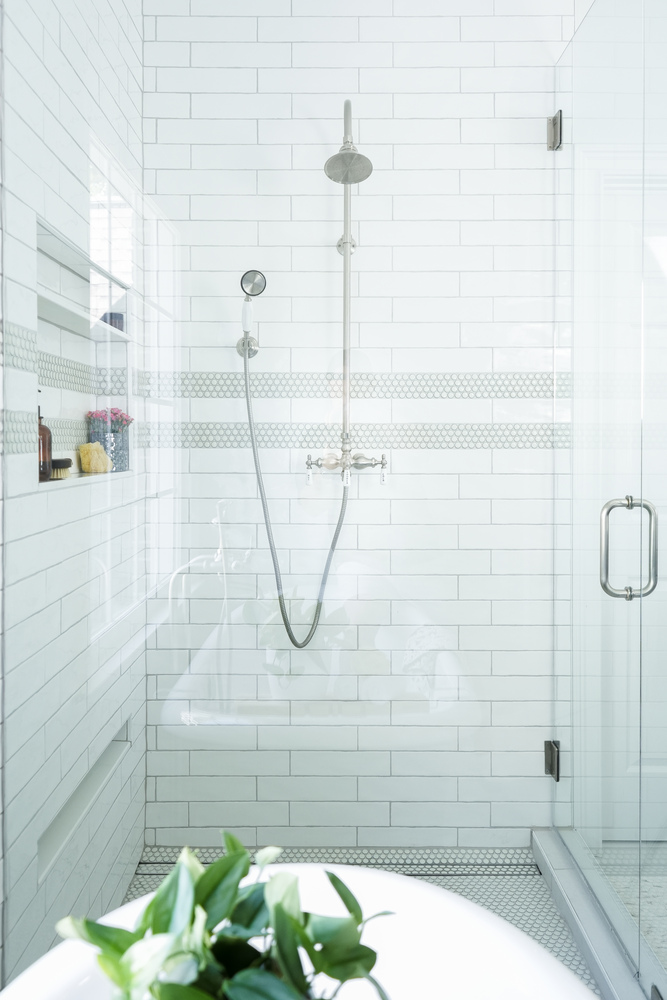 Full shower view with large tile and rain shower head by Exodus Design Build in Berkeley Lake, GA.