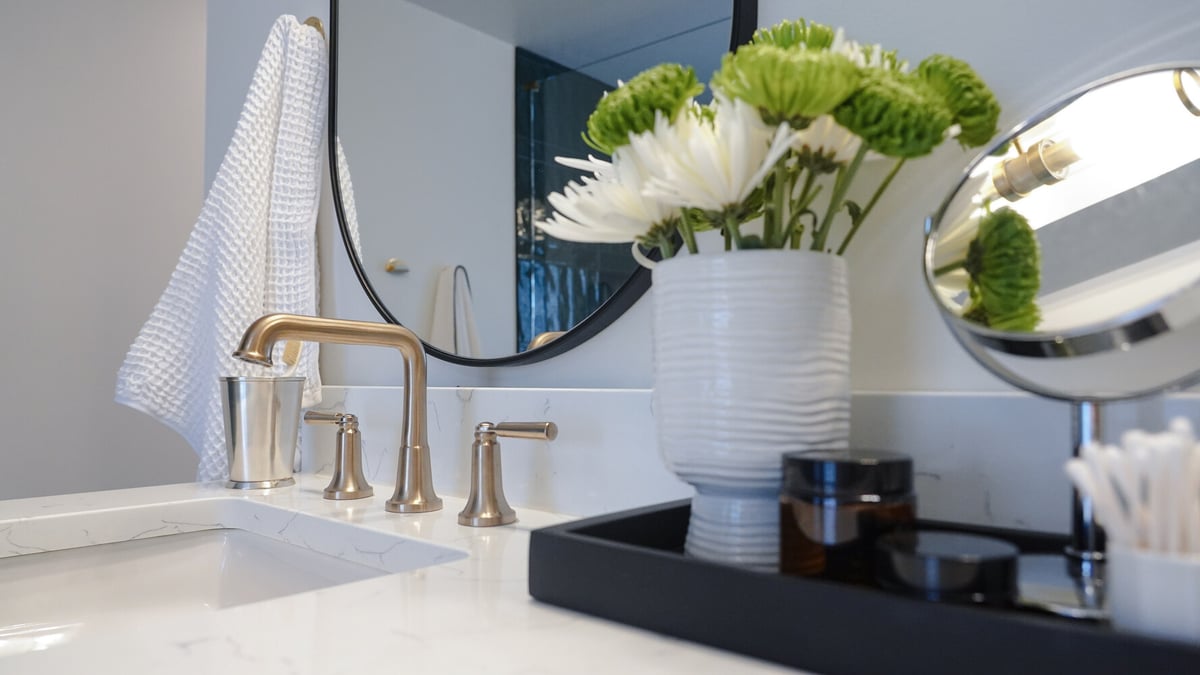 Close-up of vanity faucet and floral decor in a custom bathroom by Exodus Design Build in Grayson, GA.