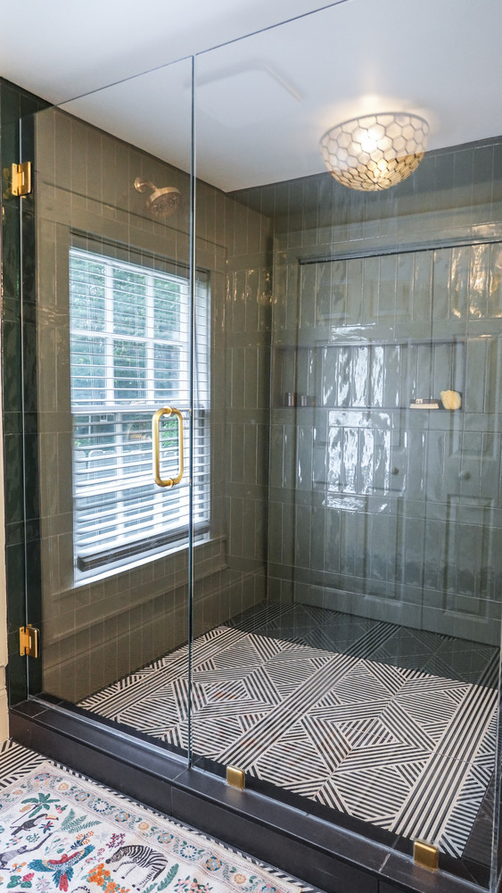Large walk-in shower with glass door and unique ceiling fixture by Exodus Design Build in Buford, GA.