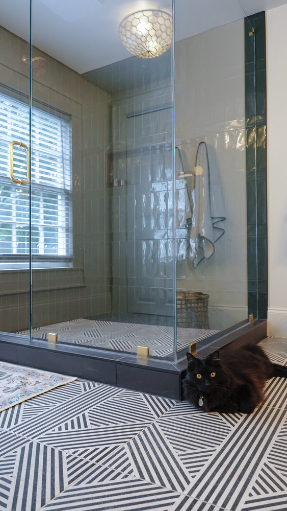 Stylish custom shower with framed glass and decorative bath mat by Exodus Design Build in Suwanee, GA.