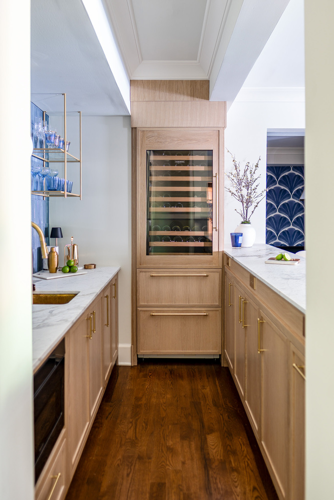 Built-in bar cabinetry with wine storage and blue tile details by Exodus Design Build in Peachtree Corners, GA