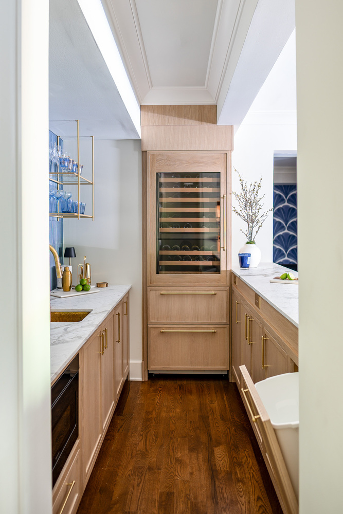 High-end home bar with under-counter fridge open, designed by Exodus Design Build in Flowery Branch, GA