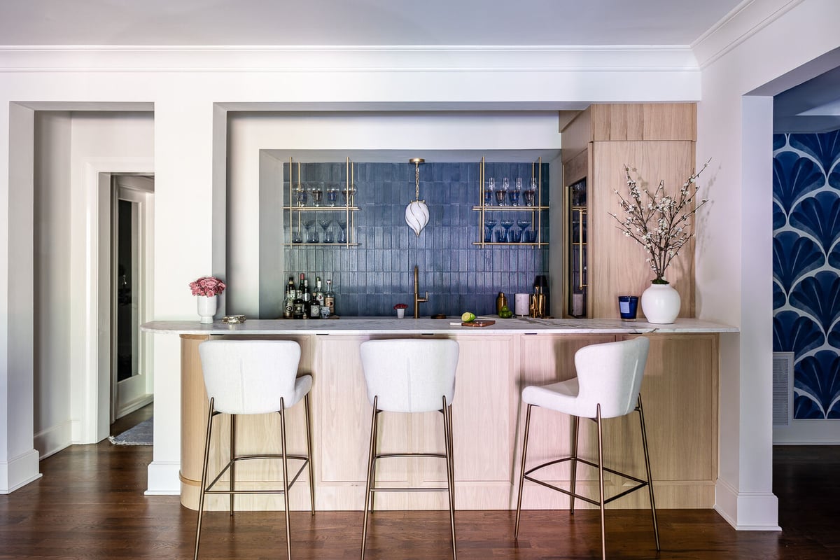 Modern home bar area featuring gold fixtures and open shelving by Exodus Design Build in Berkeley Lake, GA