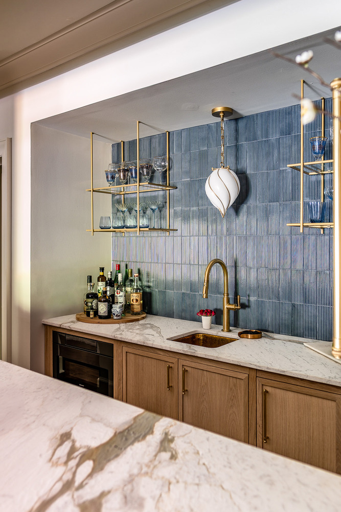 Side view of home bar with pendant lighting and hanging glass shelves in Dacula, GA by Exodus Design Build