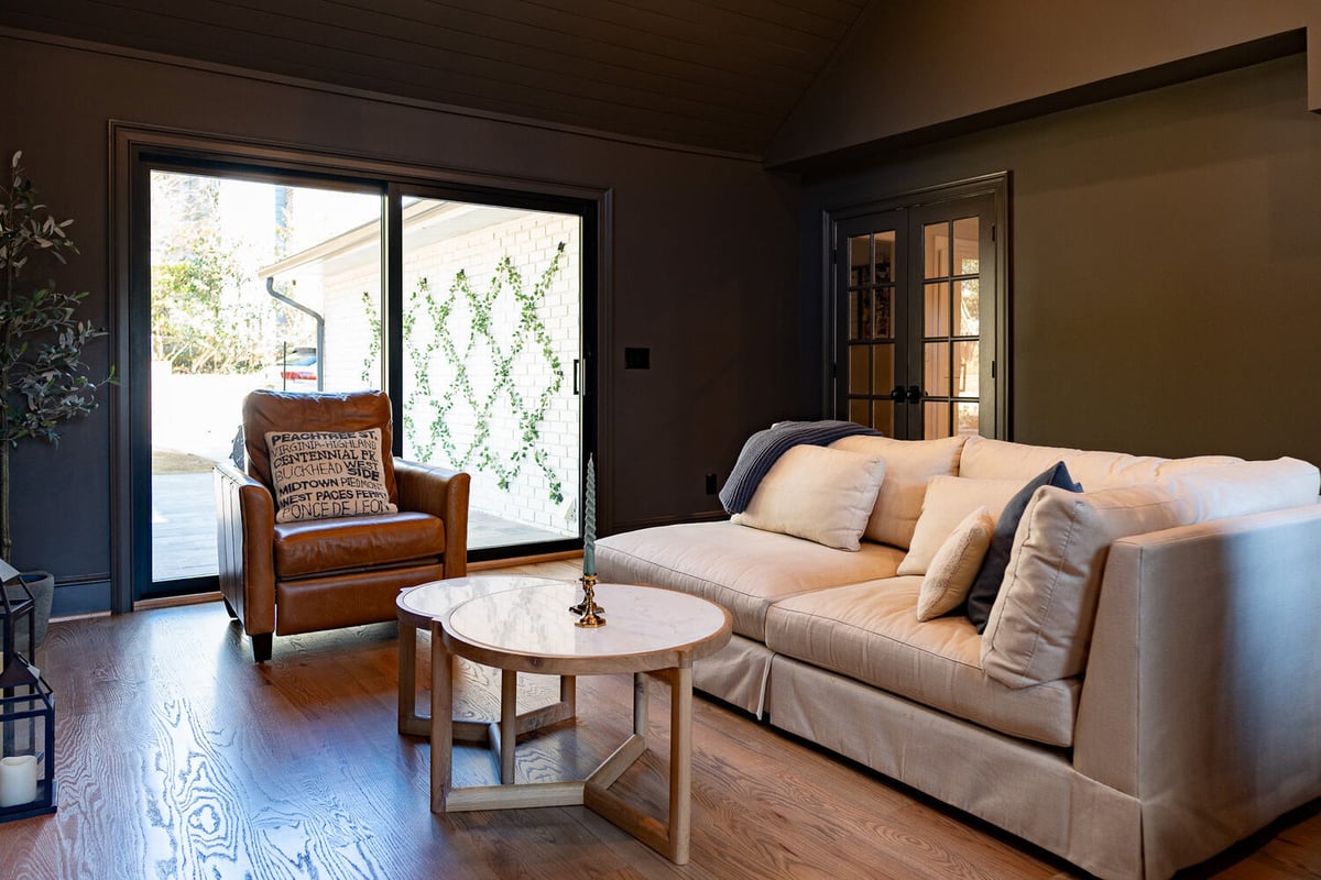 Bright living space with sliding glass doors and leather accent chair by Exodus Design Build in Stone Mountain, GA