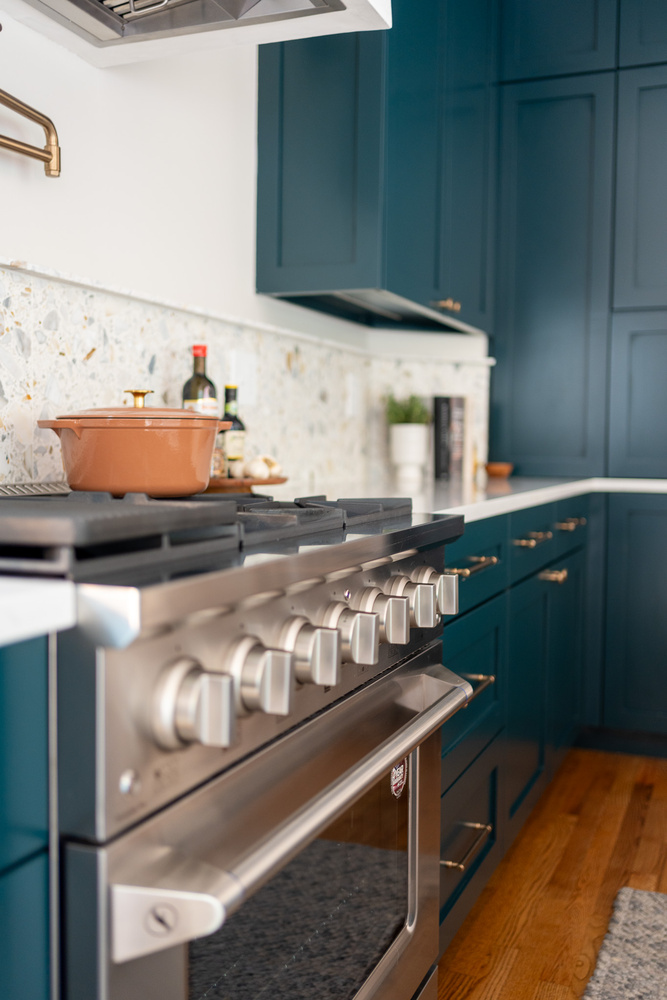Close-up of professional-grade stainless steel range with pot filler by Exodus Design Build in Peachtree Corners, GA