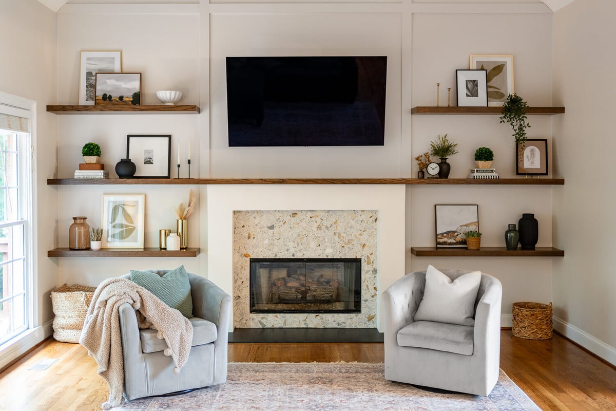 Living room fireplace with terrazzo surround and custom wood shelving by Exodus Design Build in Lilburn, GA