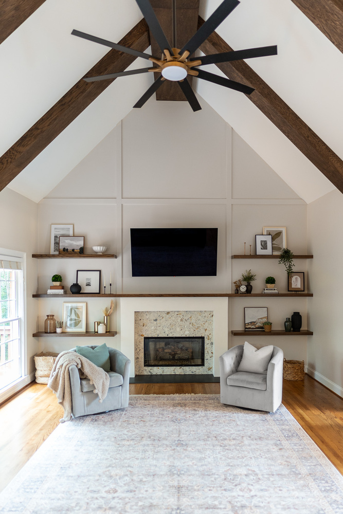 Vaulted living room ceiling with exposed beams and central fan above fireplace by Exodus Design Build in Grayson, GA