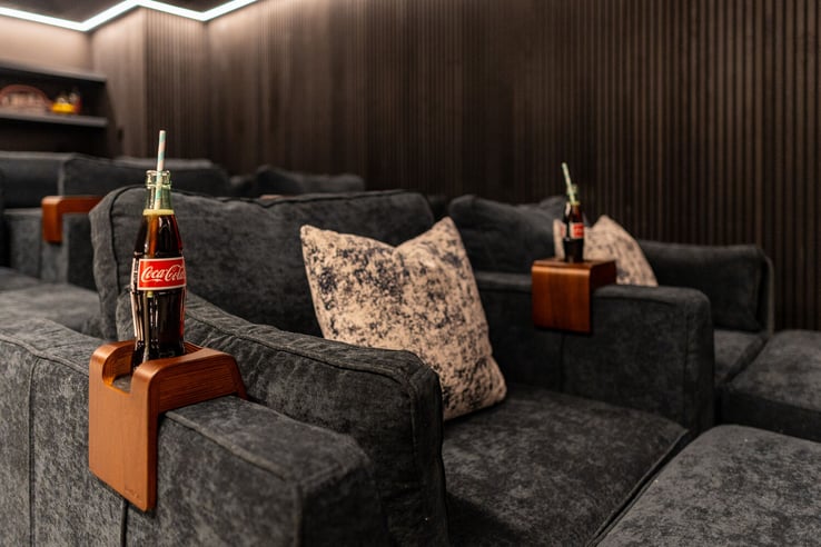 Detail of custom theater seating with Coca-Cola bottle on armrest by Exodus Design Build in Snellville, GA.