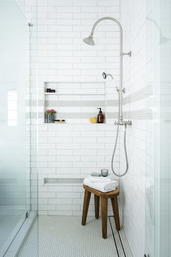 Walk-in shower with glass doors and white subway tile in custom Atlanta home by Exodus Design Build