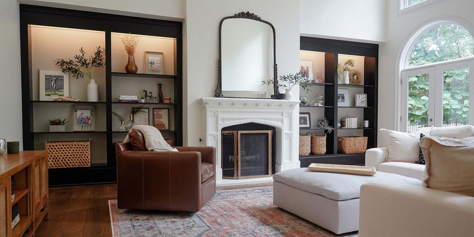 Cozy living room with white fireplace and built-in black shelving in a Fayetteville, GA custom home by Exodus Design Build