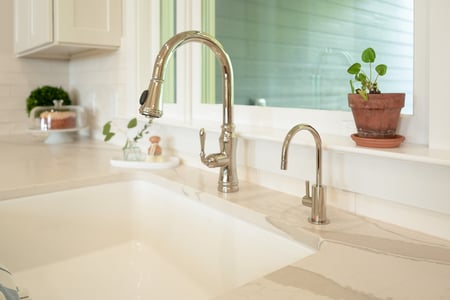 Kitchen sink with polished chrome faucet and window ledge decor in a Decatur, GA custom home by Exodus Design Build.