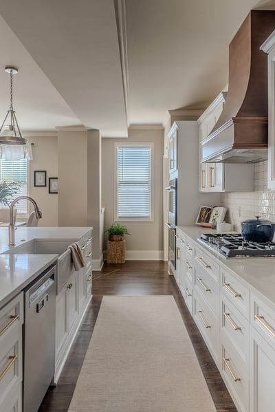 Galley-style custom kitchen with large window and hardwood floors by Exodus Design Build in Athens, GA.