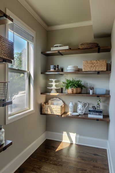 Open shelving pantry with natural light and warm wood floors in a Gainesville, GA home by Exodus Design Build.