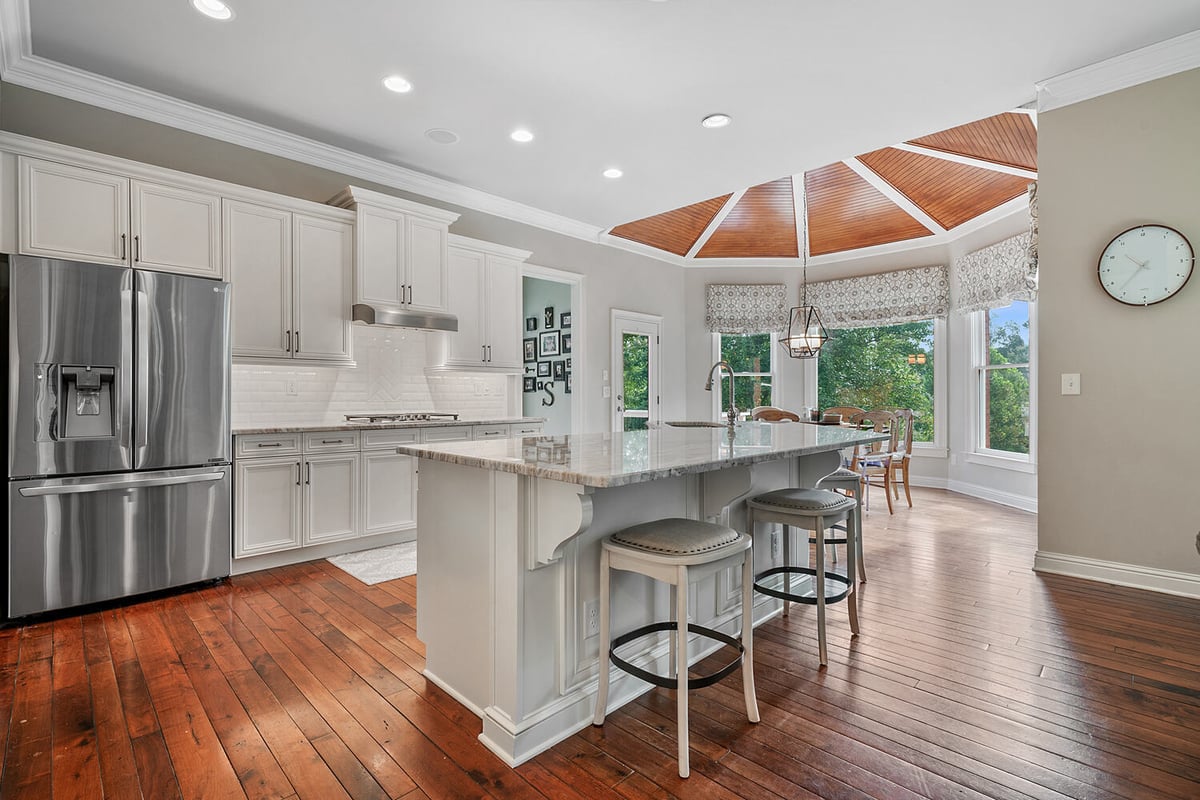 Open-concept kitchen with white cabinets and center island in a custom-built Atlanta, GA home by Exodus Design Build.
