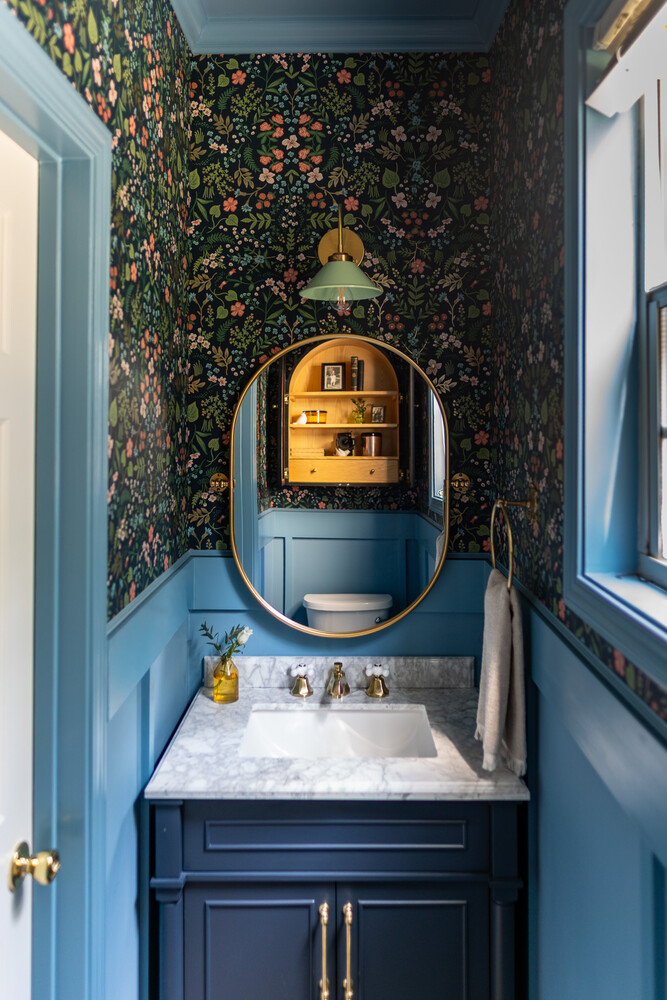 Vibrant guest bathroom remodel featuring patterned wallpaper and brass accents by Exodus Design Build in Oakwood, GA.