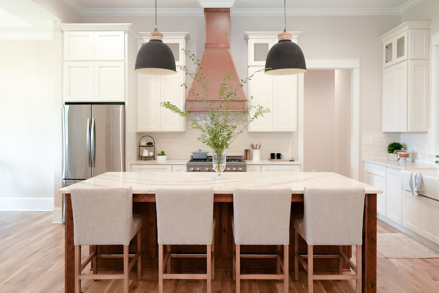 White cabinetry kitchen with natural wood accents and pendant lighting by Exodus Design Build in Grayson, GA