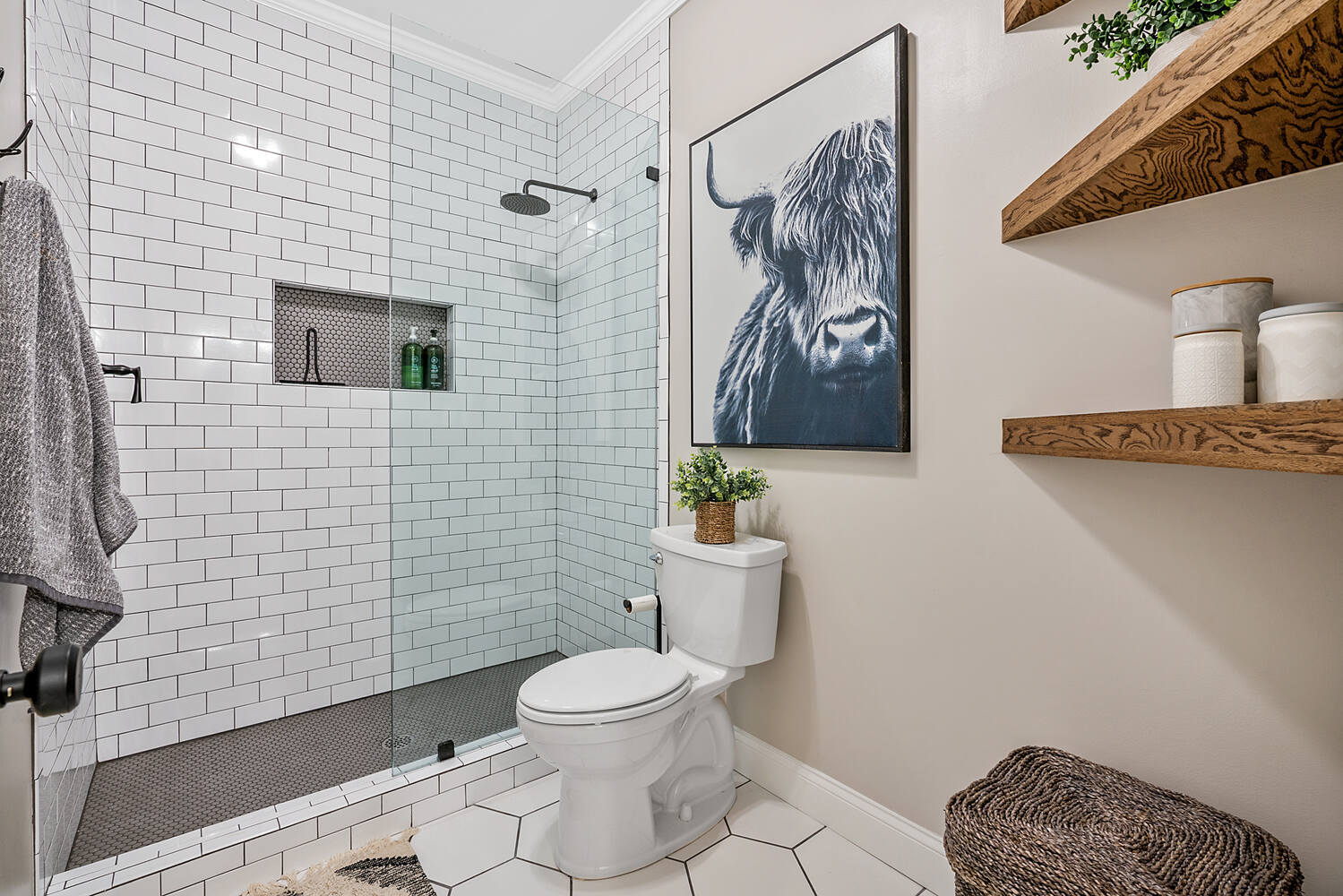 Full bathroom view with subway tile shower and hex tile niche by Exodus Design Build in Dacula, GA.