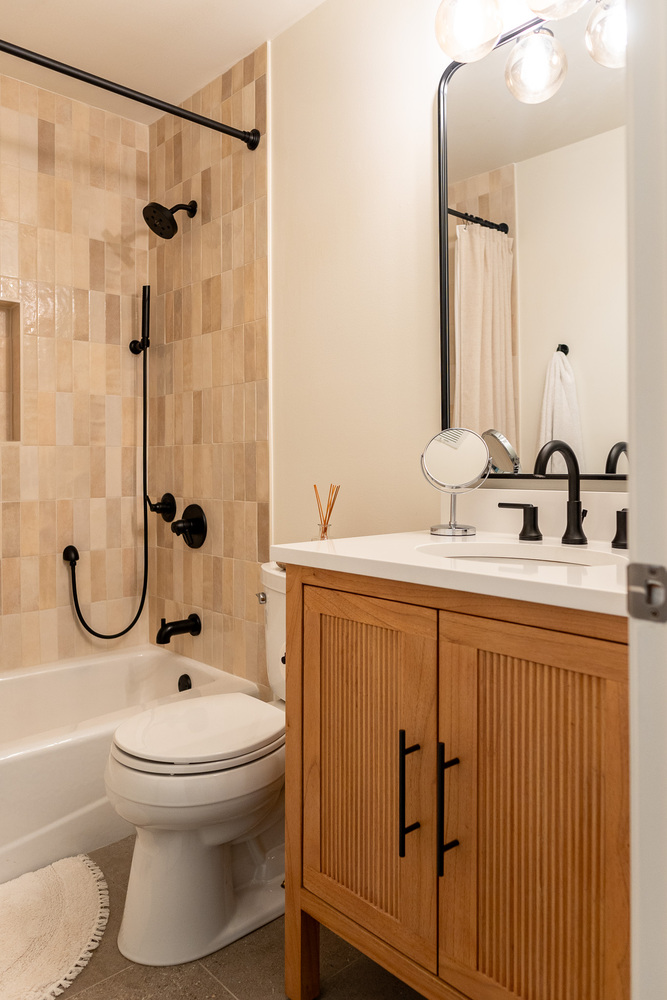 Natural wood vanity and warm-toned tile in a custom bathroom by Exodus Design Build in Buford, GA